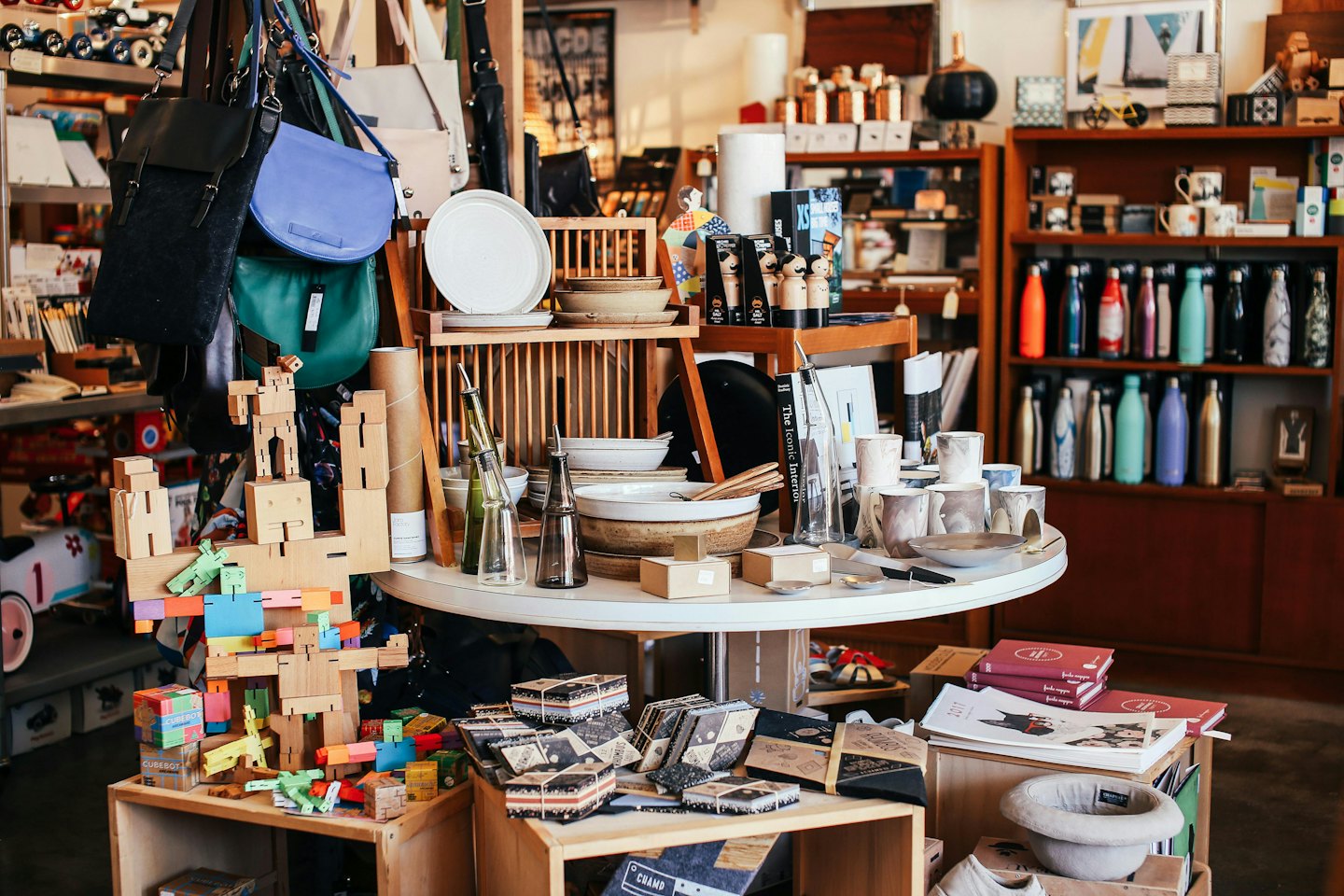 Wooden shelves and table displaying curated home goods in a boutique.